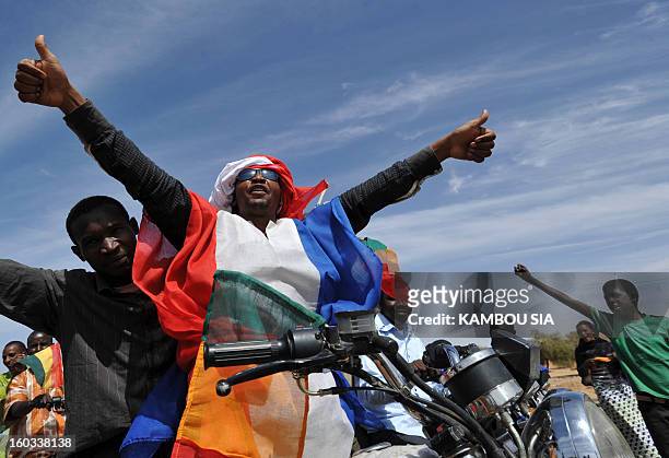 Youths celebrate on January 29, 2013 in Ansongo, a town south of the northern Malian city of Gao, as Niger troops enter the city. Troops from Niger...