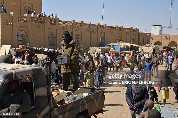 Malian soldiers patrol on a pick-up truck to keep looters at bay on January 29, 2013 in Timbuktu after French-led troops freed the northern desert...