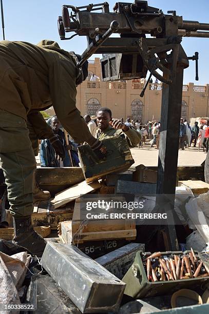 Malian soldiers recover ammunitions from a shop as they patrol on a pick-up truck to keep looters at bay on January 29, 2013 in Timbuktu after...