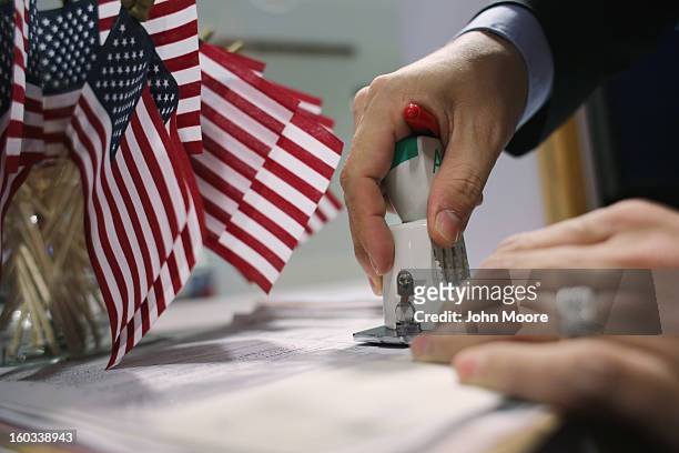 Immigration services official Andrew Diroll-Black stamps U.S. Citizenship applications for children at the U.S. Citizenship and Immigration Services...