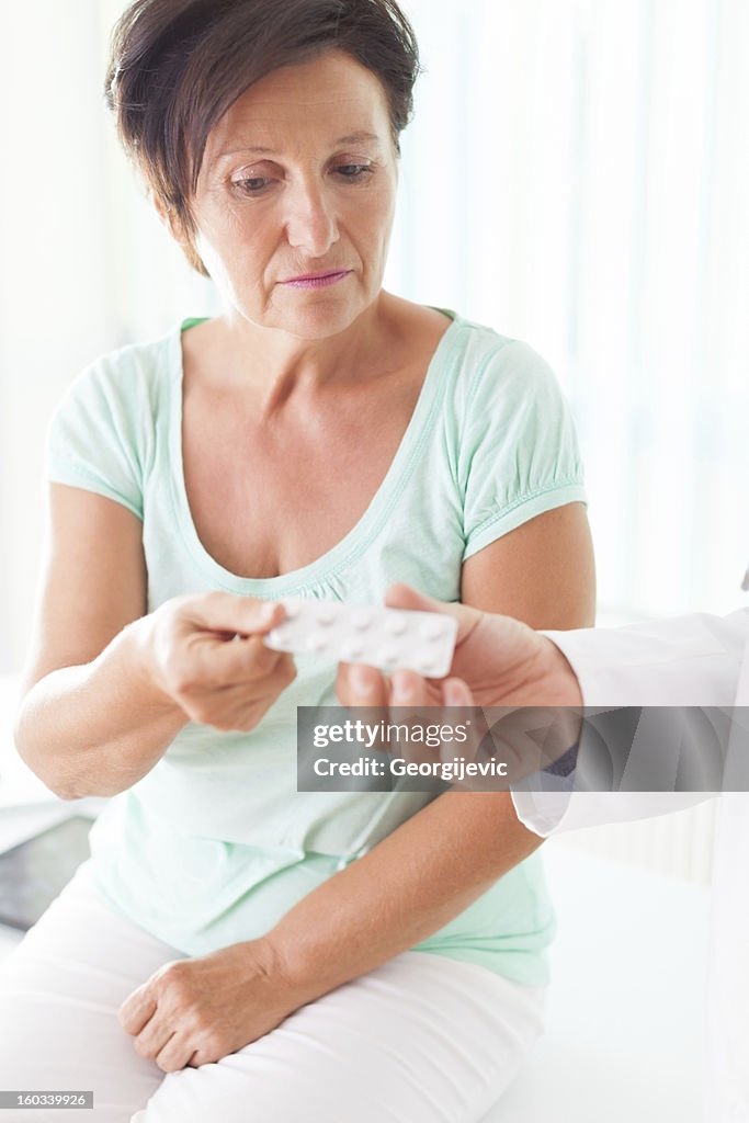 Doctor gives a medication to senior woman