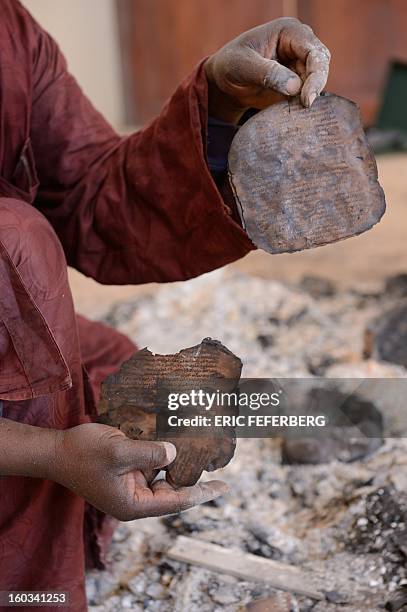 Man recovers burnt ancient manuscripts at the Ahmed Baba Centre for Documentation and Research in Timbuktu on January 29, 2013. French-led forces...