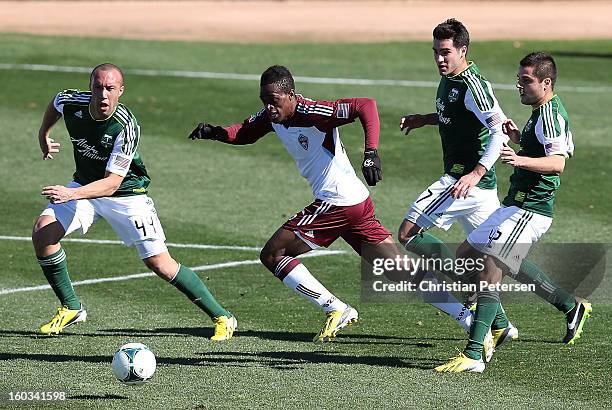 Deshorn Brown of the Colorado Rapids moves the ball past Dylan Tucker-Gagnes, Sal Zizzo and Mikael Nanchoff of the Portland Timbers during The Desert...