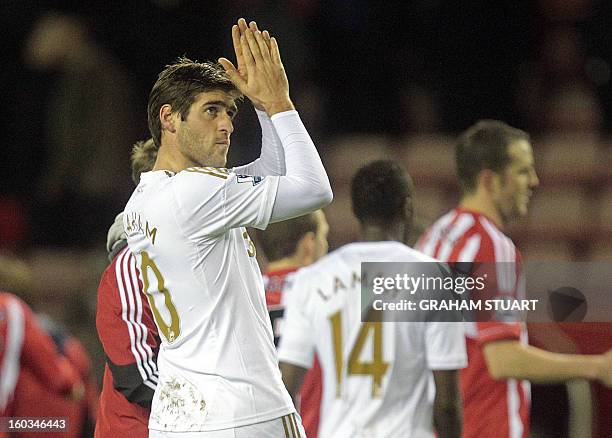 Swansea City's English midfielder Danny Graham gestures to their supporters after the English Premier League football match between Sunderland and...