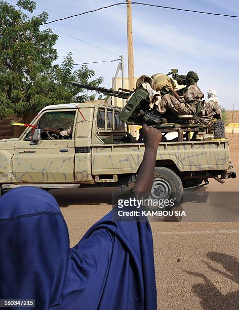 People cheer as soldiers of Malian Colonel Alaji Ag Gamou enter on January 29, 2013 Ansongo, a town south of the northern Malian city of Gao. Troops...