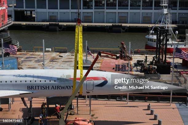 Workers prepare to place the British Airways Concorde on a harness at the Intrepid Museum on August 09, 2023 in New York City. The British Airways...