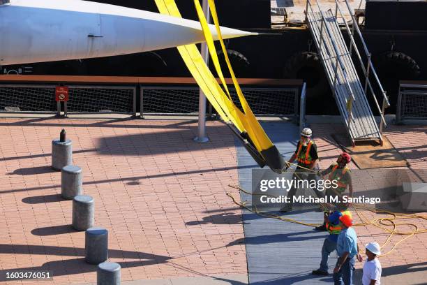 Workers place the British Airways Concorde on a harness at the Intrepid Museum on August 09, 2023 in New York City. The British Airways Concorde, the...
