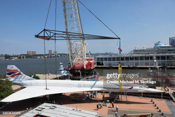 Workers place the British Airways Concorde on a harness at the Intrepid Museum on August 09, 2023 in New York City. The British Airways Concorde, the...