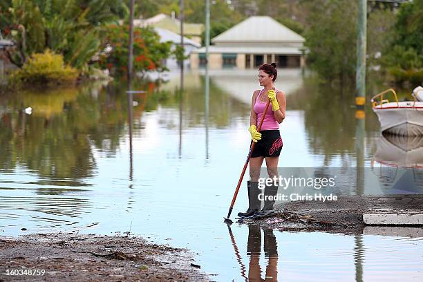 Residents clean up debris in their street as parts of southern Queensland experiences record flooding in the wake of Tropical Cyclone Oswald on...