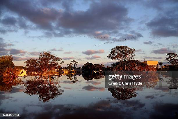 The sun rises over flooded streets as parts of southern Queensland experiences record flooding in the wake of Tropical Cyclone Oswald on January 30,...