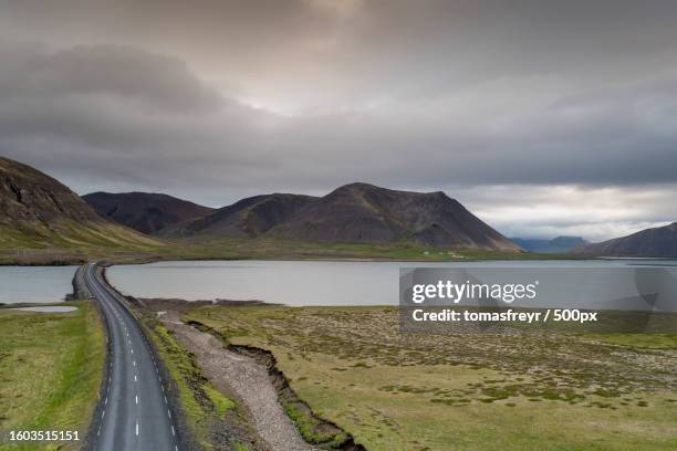 scenic view of road by mountains against sky - landslag imagens e fotografias de stock