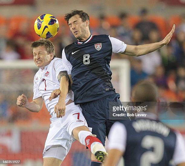 Brad Evans of the USA goes up for a header against Terry Dunfield of Canada in the first half at BBVA Compass Stadium on January 29, 2013 in Houston,...