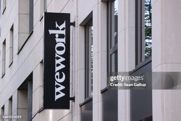 The logo of WeWork hangs on a building where the company offers co-working space on August 09, 2023 in Berlin, Germany. The company reported doubt in...