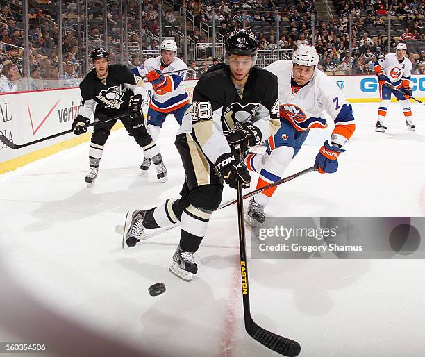 Tyler Kennedy of the Pittsburgh Penguins watches the loose puck in front of Matt Carkner of the New York Islanders on January 29, 2013 at Consol...