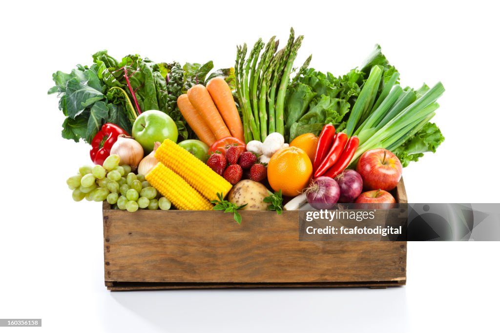 Fruits and veggies in wood box with white backdrop