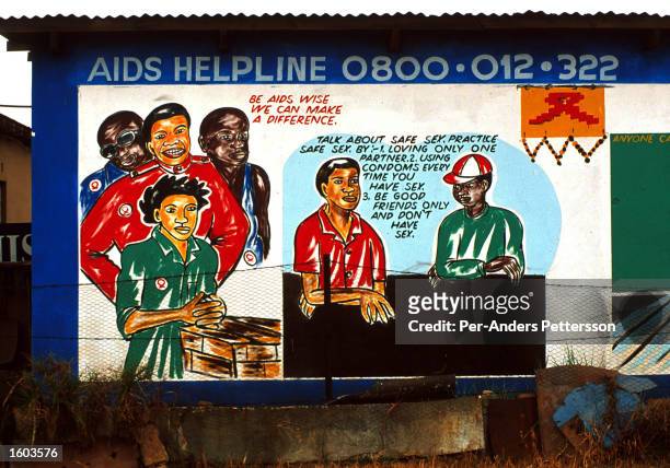 Mural displays a public service announcement about HIV and AIDS June 16, 2000 in a residential area in Thokosa, a township outside Johannesburg,...