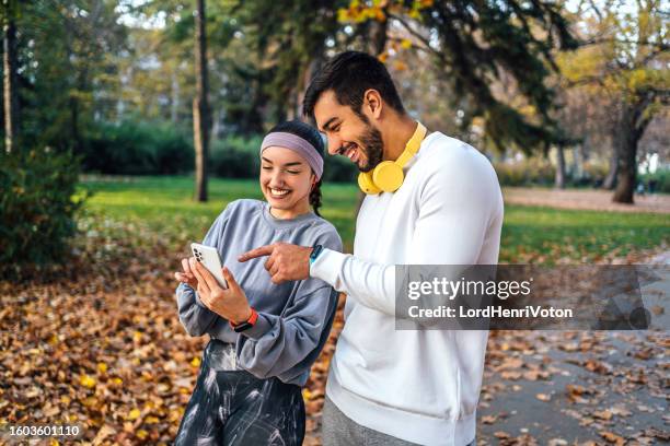 young sporty couple using smartphone - boyfriend day stock pictures, royalty-free photos & images
