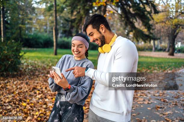 young sporty couple using smartphone - outubro imagens e fotografias de stock