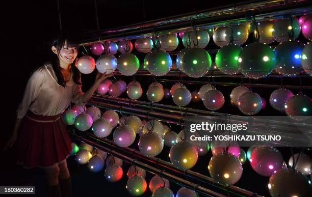 Sayane Egawa, an employee of Japanese weather forecasting company Weathernews displays some of the 1,000 pod-shaped pollen counting robots called...