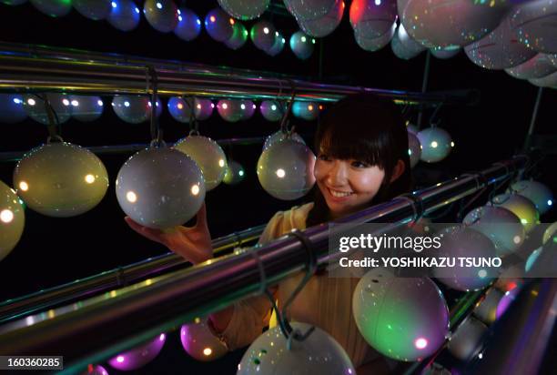 Sayane Egawa, an employee of Japanese weather forecasting company Weathernews displays some of the 1,000 pod-shaped pollen counting robots called...