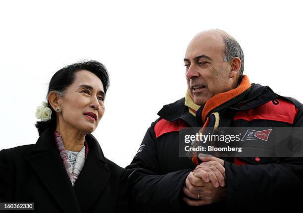 Aung San Suu Kyi, Myanmar's opposition leader, left, talks to Muhtar Kent, chief executive officer of Coca-Cola Co., during a visit to the 2013...