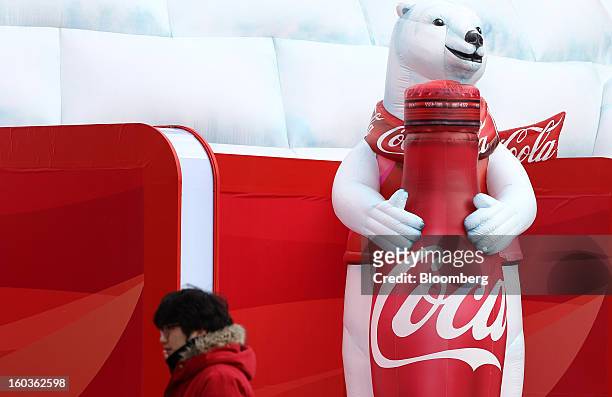 Coca-Cola Co. Event employee walks past the company's promotion booth at the 2013 Pyeongchang Special Olympics Winter Games in Pyeongchang, South...