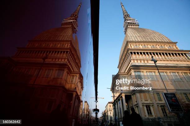 Pedestrians pass the Mole Antonelliana, right, in Turin, Italy, on Tuesday, Jan. 29, 2013. Italy sold 8.5 billion euros of six-month Treasury bills...