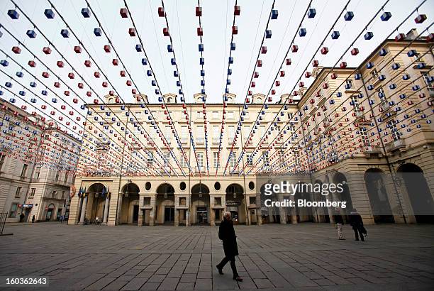 Pedestrians cross Palazzo di Citta square in Turin, Italy, on Tuesday, Jan. 29, 2013. Italy sold 8.5 billion euros of six-month Treasury bills as...