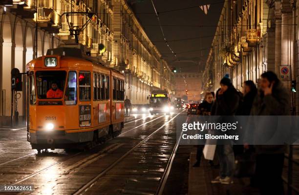 Commuters wait for a tram at a tram stop at night in Turin, Italy, on Tuesday, Jan. 29, 2013. Italy sold 8.5 billion euros of six-month Treasury...