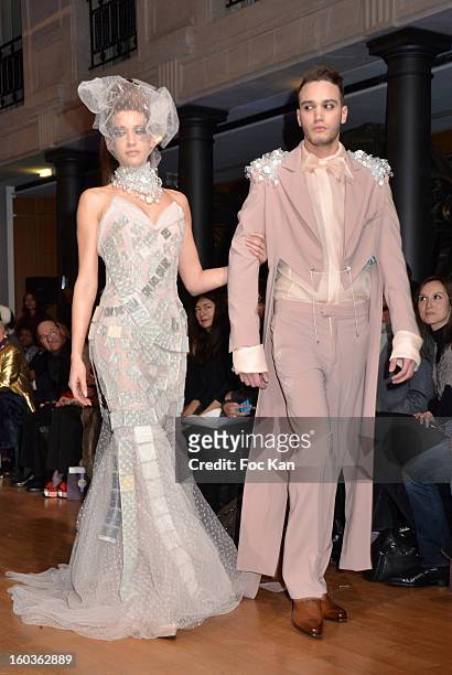 Two models walk the runway during the Eric Tibusch Spring/Summer 2013 Haute-Couture show as part of Paris Fashion Week at Hotel D'Evreux on January...