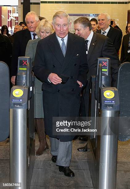 Prince Charles, Prince of Wales and Camilla, Duchess of Cornwall walk through a ticket gate as they prepare to travel on a Metropolitan underground...