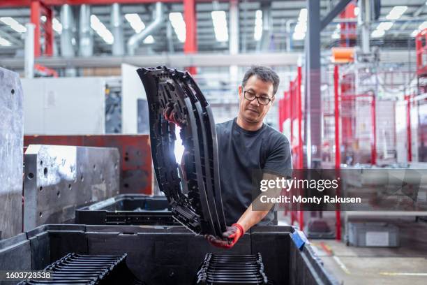 worker packing moulded product in automotive parts factory - injection molding stock pictures, royalty-free photos & images