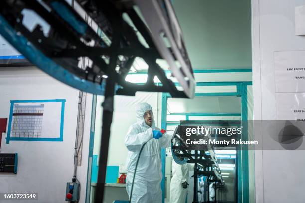 worker cleaning moulded product in automotive parts factory - spray booth stock pictures, royalty-free photos & images