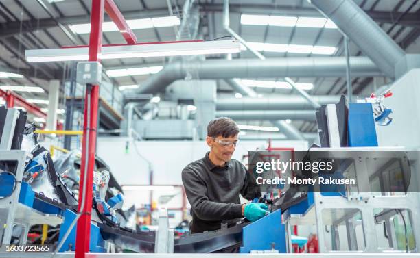 worker assembling plastic injection moulded parts in automotive parts factory - injection molding stock pictures, royalty-free photos & images