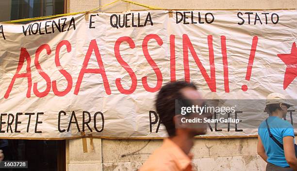 Sign hung by demonstrators brands Italian police as assassins July 23, 2001 in Rome, Italy during a protest against the shooting death of Carlo...