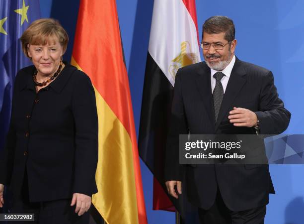 German Chancellor Angela Merkel and Egyptian President Mohamed Mursi depart after speaking to the media following talks at the Chancellery on January...