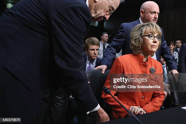 Sen. Charles Grassley helps shooting victim and former U.S. Rep. Gabby Giffords and her husband, retired NASA astronaut and Navy Capt. Mark Kelly, as...