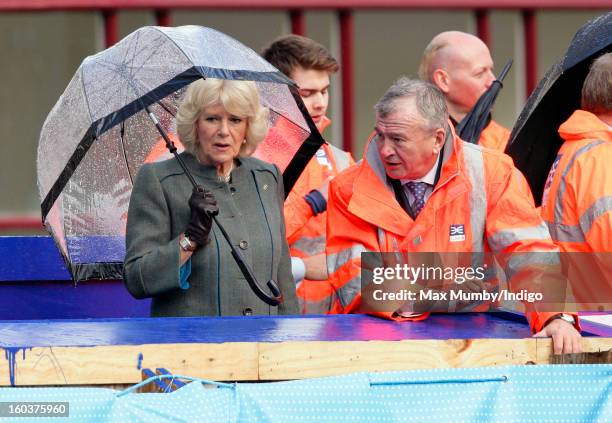 Camilla, Duchess of Cornwall shelters under an umbrella as she views the Crossrail development site before travelling on a Metropolitan line...