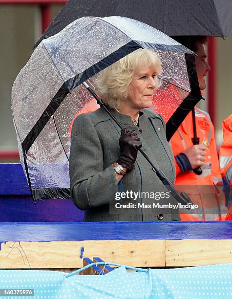 Camilla, Duchess of Cornwall shelters under an umbrella as she views the Crossrail development site before travelling on a Metropolitan line...