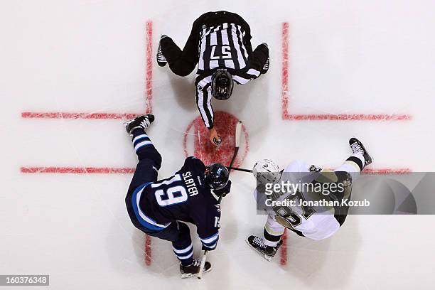 Jim Slater of the Winnipeg Jets takes a second period face-off against Sidney Crosby of the Pittsburgh Penguins at the MTS Centre on January 25, 2013...