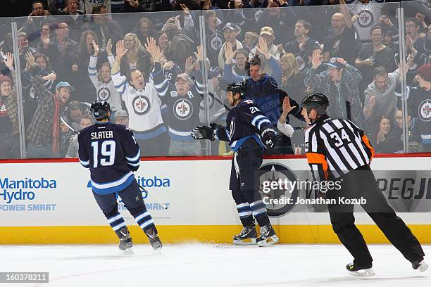 Blake Wheeler of the Winnipeg Jets celebrates an empty net goal against the Pittsburgh Penguins with teammate Jim Slater in front of enthusiastic...