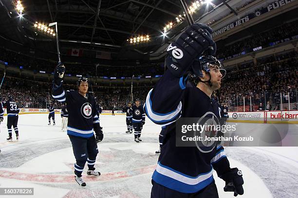 Nik Antropov and Andrew Ladd of the Winnipeg Jets salute the fans from centre ice following a 4-2 victory over the Pittsburgh Penguins at the MTS...