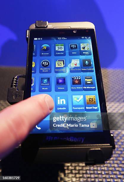 Worker demonstrates the use of the new BlackBerry Z10 at the BlackBerry 10 launch event at Pier 36 in Manhattan on January 30, 2013 in New York City....