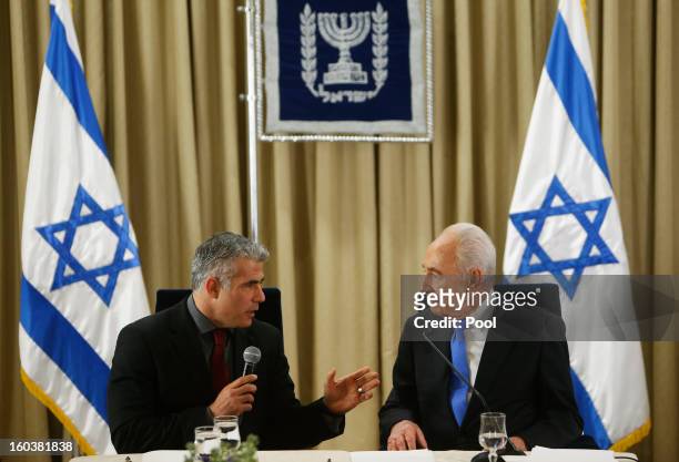 Israel's President Shimon Peres listens as Yair Lapid, leader of the Yesh Atid party, speaks during their meeting on January 30, 2013 in Jerusalem,...