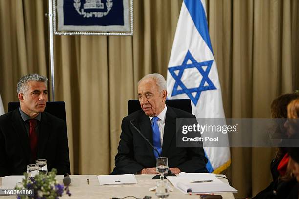 Israel's President Shimon Peres listens as Yair Lapid, leader of the Yesh Atid party, speaks during their meeting on January 30, 2013 in Jerusalem,...