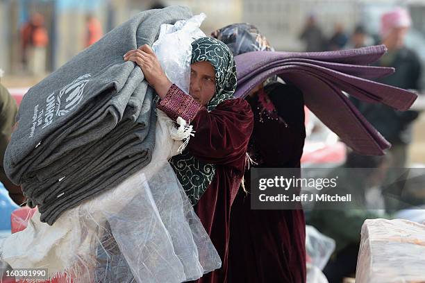 Refugees from Syria collect blankets and supplies from the UNHCR as they arrive at the Za’atari refugee camp on January 30, 2013 in Mafrq, Jordan....