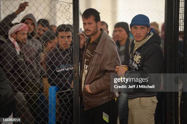 Refugees from Syria queue to collect food and supplies from the UNHCR as they arrive at the Za’atari refugee camp on January 30, 2013 in Mafrq,...