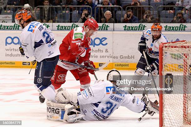 Andreas Falk of Cologne misses a chance at goal under the pressure of goalkeeper Shawn Hunwick and Brandon Rogers of Iserlohn during the DEL match...