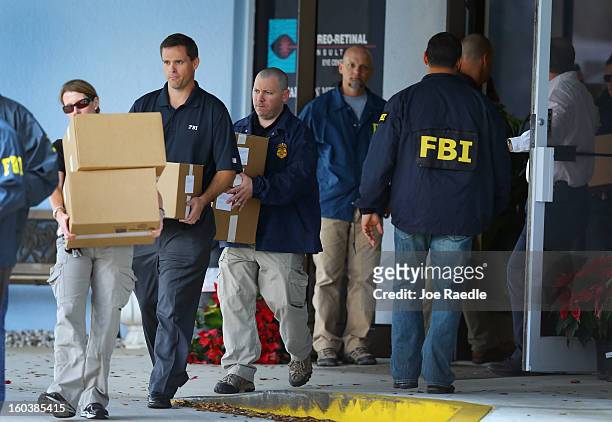 Agents carry out boxes as law enforcement officials investigate the medical-office complex of Dr. Salomon Melgen who has possible ties to U.S. Sen....