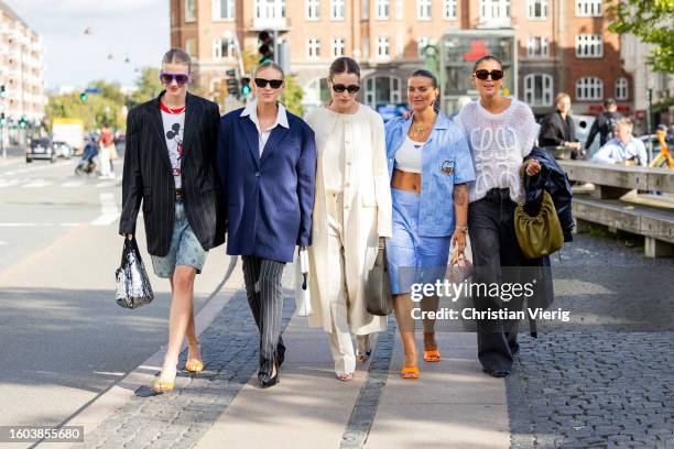 Marianne Theodorsen wears black oversized blazer, Micky Mouse print short, denim shorts, silver sequined bag, pink sunglasses, orange heels & Tine...